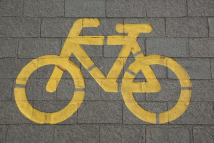 Straattegels waar een fiets met gele verf op is gespoten.